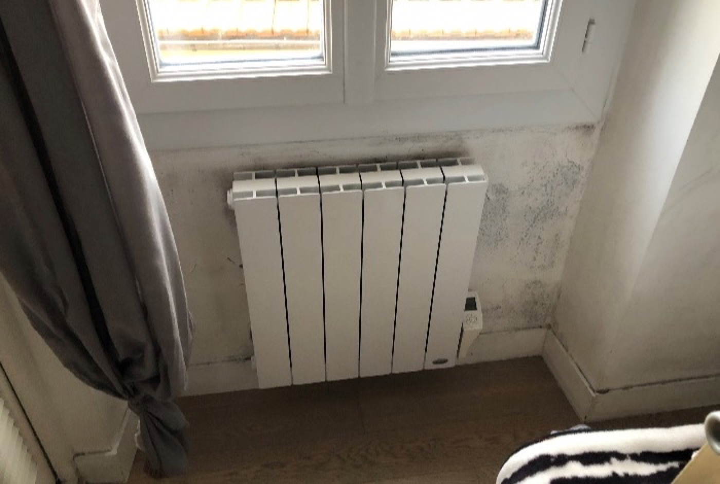 Traces d'humidité dans le renfoncement d'une fenêtre, au-dessus d'un radiateur
