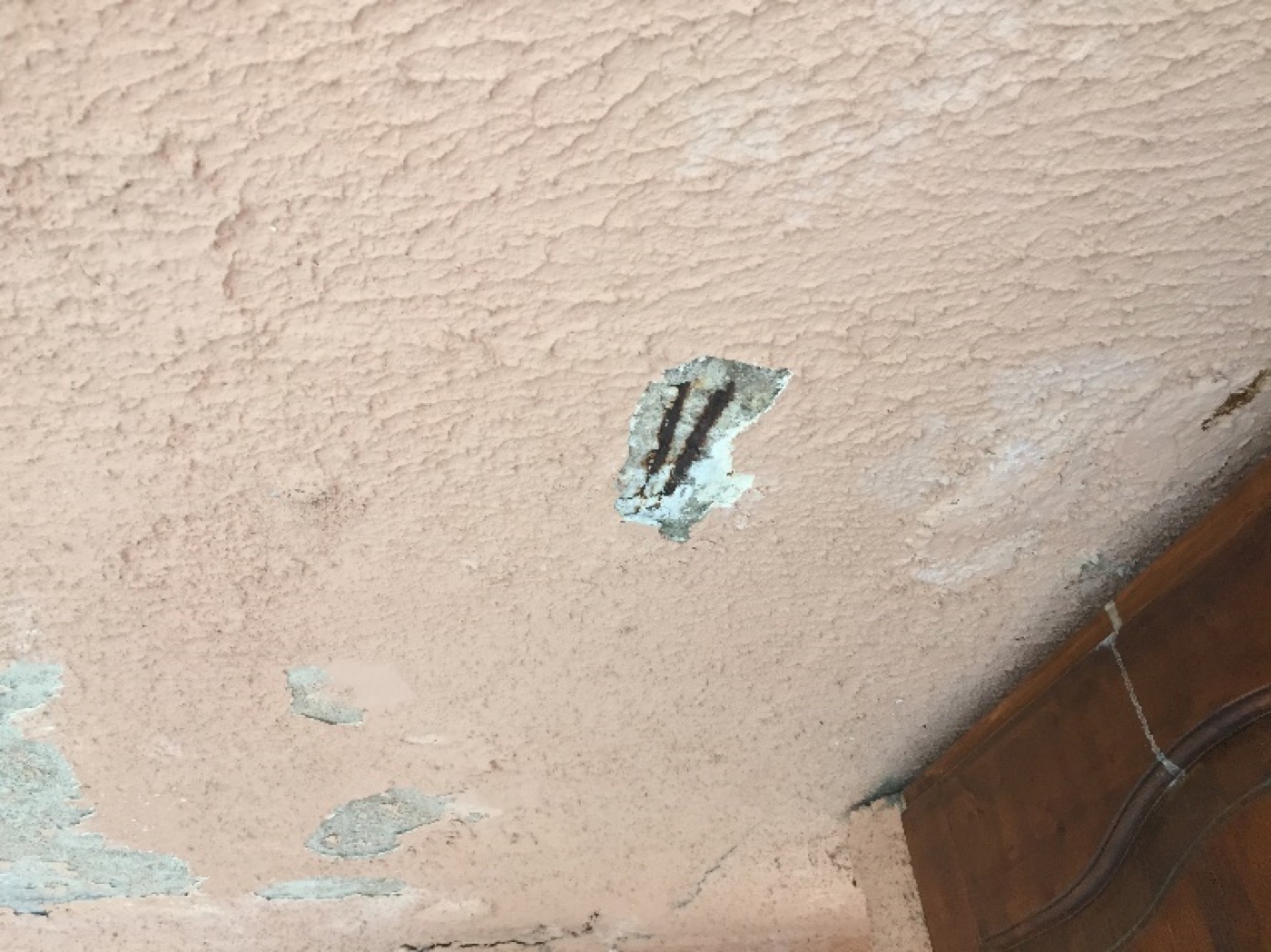 Sous-face de balcon dégradée, revêtement décollé et armature apparente