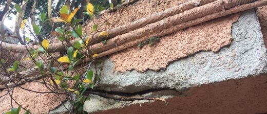 Éclat de béton et armatures corrodées apparentes sous une passerelle, diagnostic à Menton