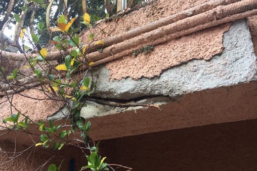Éclat de béton et armatures corrodées apparentes sous une passerelle, diagnostic à Menton